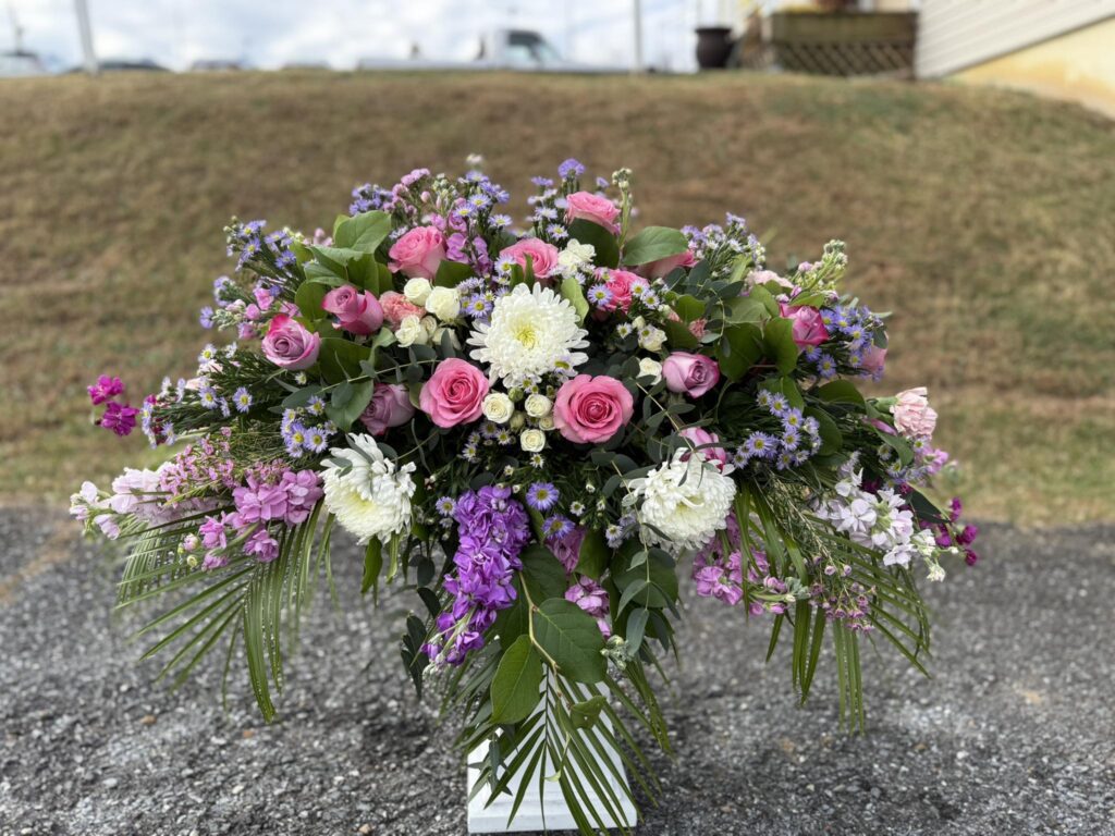 pink, purple, and white casket spray